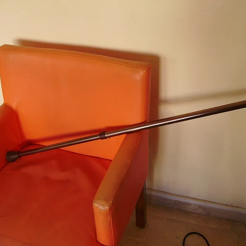 Un bastón apoyado en un sillón